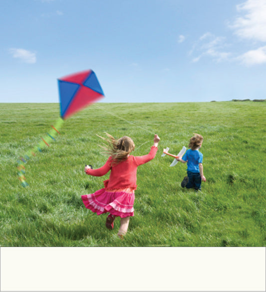Shiur VaShir image of two children running across a grassy field under a blue sky, with a red and blue kite flying in the air.